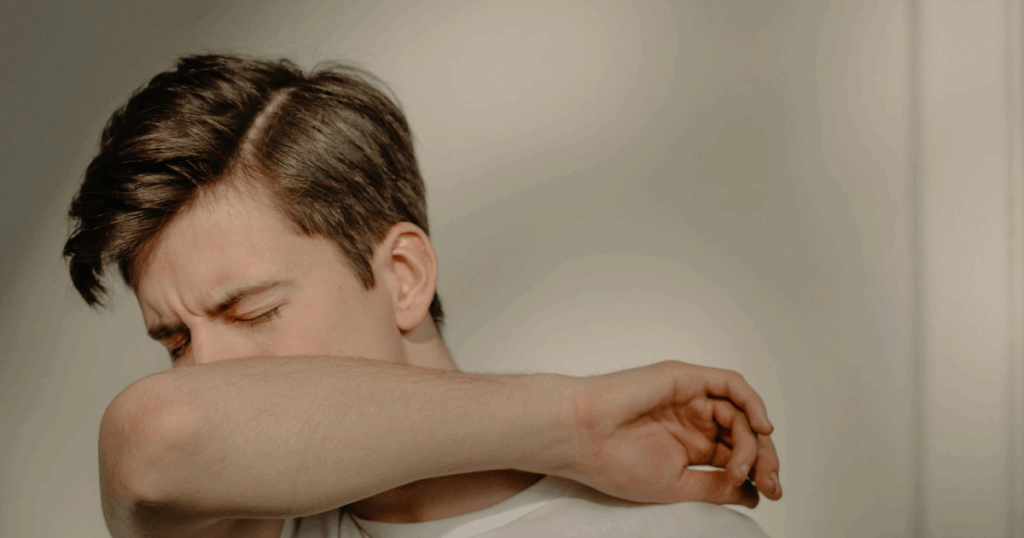 Anxious man covering face with arm, a calming technique for easing anxiety and stress. Mental health awareness and self-soothing.