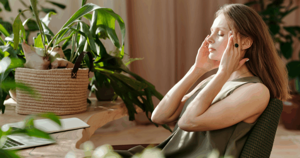 CBD for Anxiety Relief: Calming Effects and Natural Remedies - Los Angeles Mental Health Woman experiencing anxiety, potentially finding calming effects of CBD. Indoor plants and a laptop are nearby.