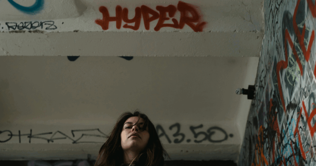 Art therapy insight: Woman under graffiti, exploring schizophrenia through art and urban expression. Mental health awareness.