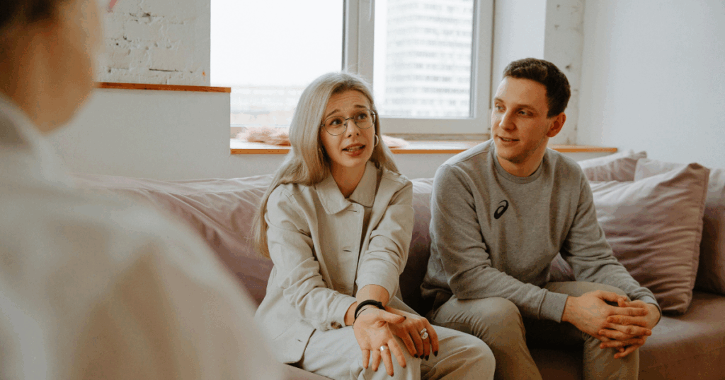Couple in therapy session, discussing relationship issues with therapist. Unlocking connection through couples therapy.